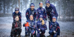 En gruppbild på Malungs IF - skidor. På bilden är det barn samt ledare som tittar in i kameran. Nysnö faller stämningsfullt.