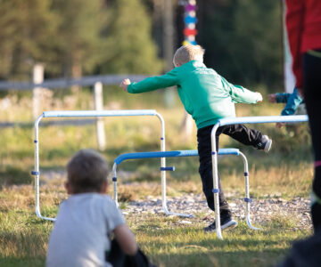 Ett barn hoppar över hinder.