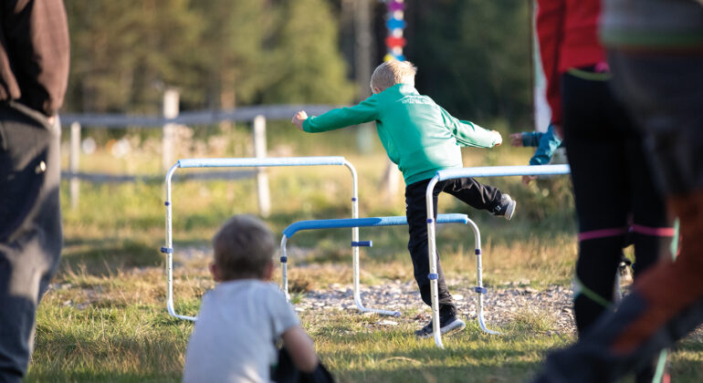 Ett barn hoppar över hinder.